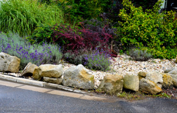 sandstone walls and stones in a flowerbed in a terraced terrain with stairs, 